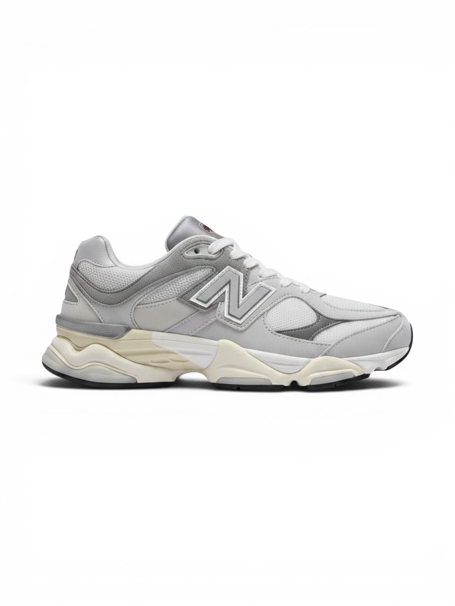 Tenis New Balance 9060 grises para niños, con detalles plateados y suela de goma. Diseño deportivo y moderno.