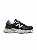 Tenis New Balance 9060 negros y grises para hombre, con detalles blancos y suela gruesa de goma.