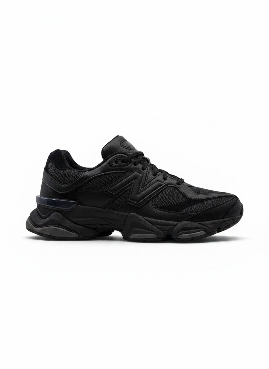 Tenis New Balance 9060 negros para hombre, con detalles de malla y suela gruesa. Estilo deportivo y moderno.