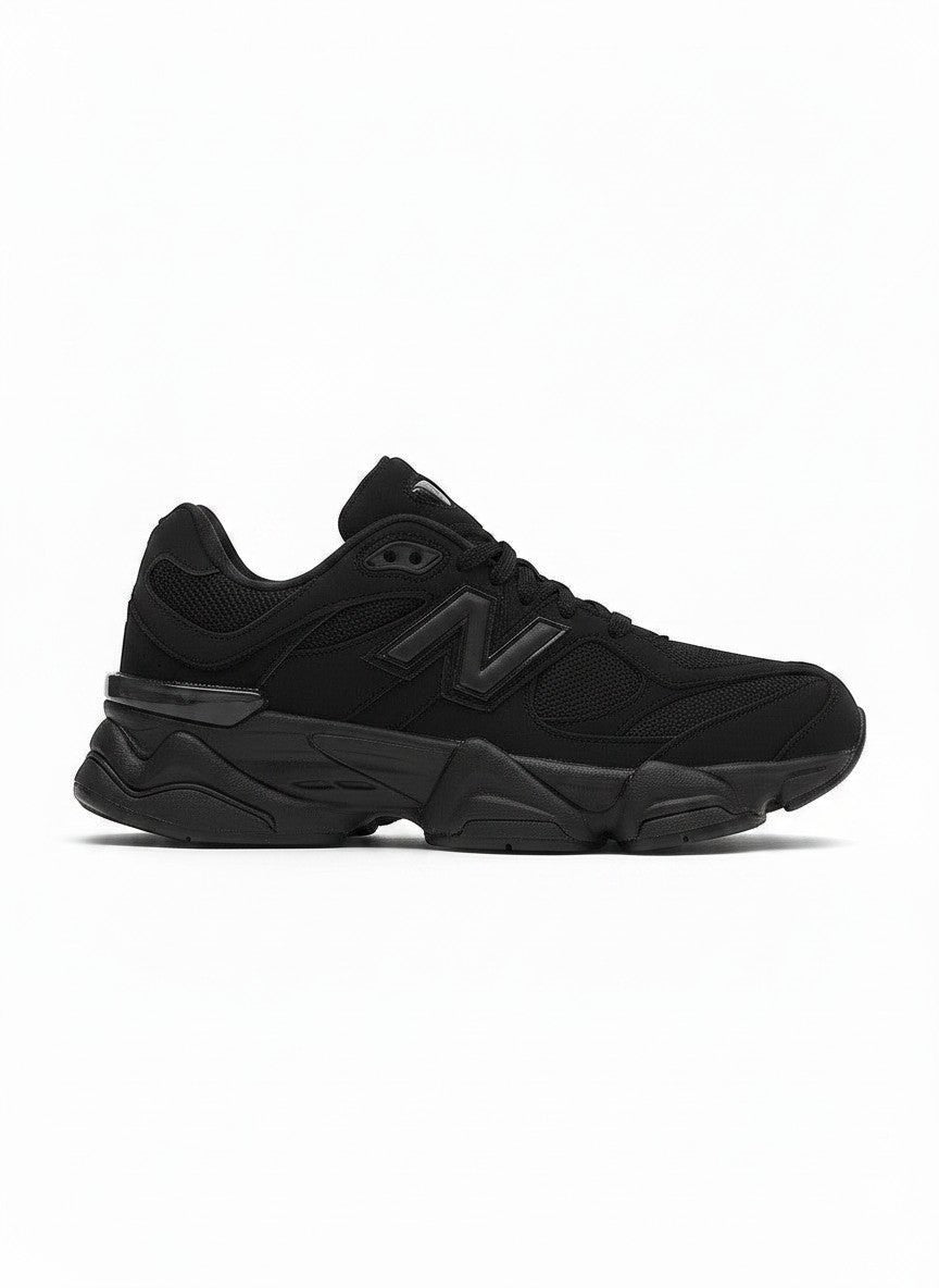 Tenis negros New Balance 9060 para niños, con detalles de malla y suela gruesa. Estilo deportivo y moderno.