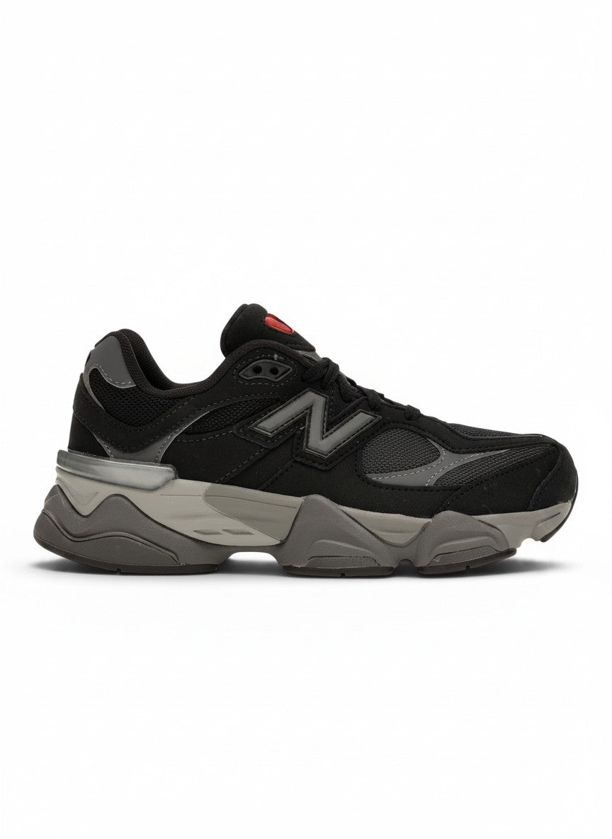 Zapatillas deportivas New Balance 9060 negras y grises para niños, con detalles de malla y suela gruesa para máximo confort.